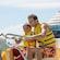 A father and son steer an Aqua Cycle Water Trike with a Disney Cruise Line ship behind them